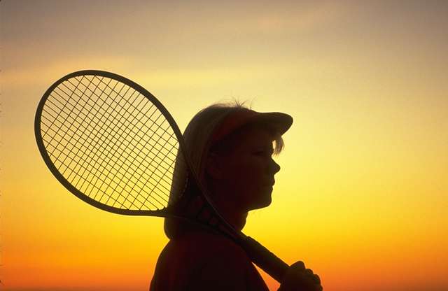 Mujer con raqueta al atardecer 